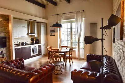 a living room with a leather couch and a table at Industrial Loft Trastevere Station in Rome