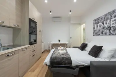 a bedroom with a bed and a kitchen at PL Guest House in Rome