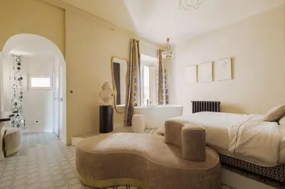 a bedroom with a large bed and a tub and a sink at Via Veneto Supreme Terrace in Rome