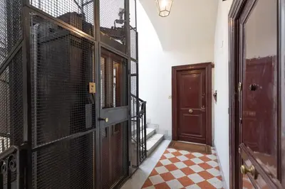 a hallway with a gate and a door with a checkered floor at Via Veneto Supreme Terrace in Rome