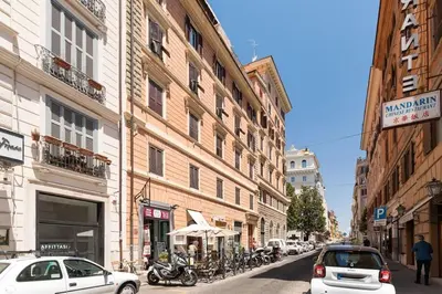 a city street with cars and motorcycles parked on the street at Via Veneto Supreme Terrace in Rome