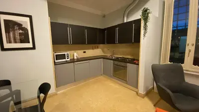 a small kitchen with grey cabinets and a microwave at La Casetta di Miriam a Piazza di Spagna in Rome