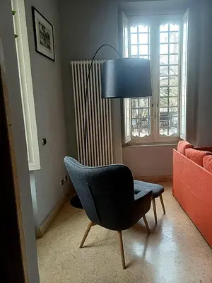 a living room with a chair and a lamp at La Casetta di Miriam a Piazza di Spagna in Rome