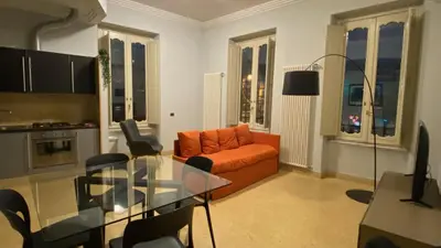 a living room with an orange couch and a glass table at La Casetta di Miriam a Piazza di Spagna in Rome