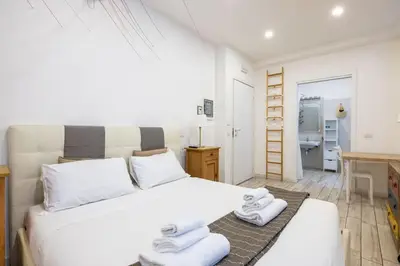 a bedroom with a white bed and a desk at Vatican Momahouse Luxury by Varental in Rome