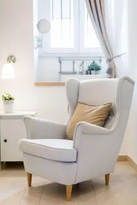 a white chair with a pillow in a living room at Vatican Momahouse Luxury by Varental in Rome
