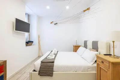 a white bedroom with a bed and a tv at Vatican Momahouse Luxury by Varental in Rome