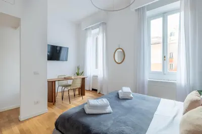 a white bedroom with a bed and a table at Venere in Trevi in Rome