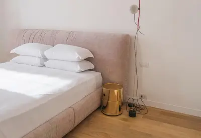 a bed with white pillows and a lamp on the floor at Youroom Margutta in Rome
