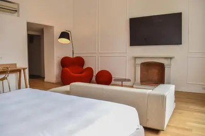 a bedroom with a bed and a couch and a fireplace at Youroom Margutta in Rome