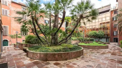 a courtyard with palm trees in front of a building at Giove in Trevi in Rome
