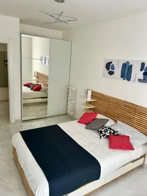a bedroom with a large bed with red and blue pillows at Urban Chic San Paolo Apartment Rome in Rome