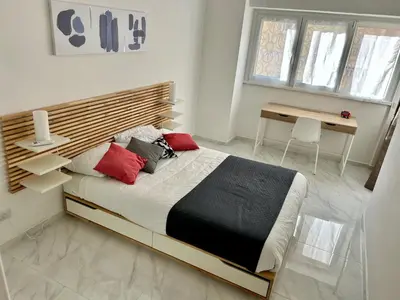 a bedroom with a large bed with a wooden headboard at Urban Chic San Paolo Apartment Rome in Rome