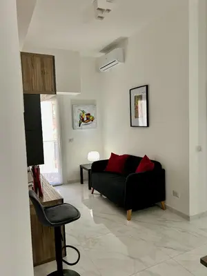a living room with a black couch and a chair at Urban Chic San Paolo Apartment Rome in Rome