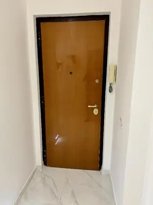a wooden door in a hallway with a tile floor at Urban Chic San Paolo Apartment Rome in Rome