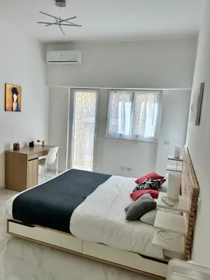 a bedroom with a large bed and a desk at Urban Chic San Paolo Apartment Rome in Rome