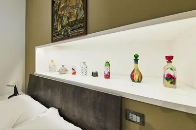 a shelf above a bed with vases on it at iFlat One step from Colosseum in Rome