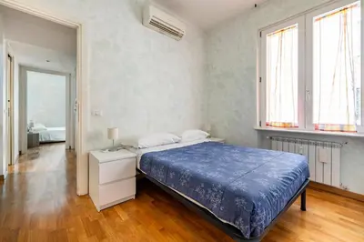 a bedroom with a bed with a blue comforter at Comfortable apartment Via Appia - B in Rome