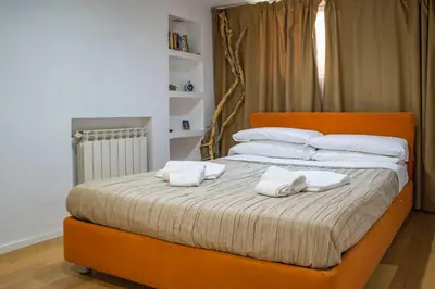 an orange bed with two white towels on it at Campo De Fiori- Deluxe&Relax in Rome