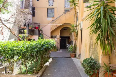 an alley in an apartment building with trees and plants at Campo De Fiori- Deluxe&Relax in Rome