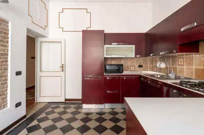 a kitchen with brown cabinets and a checkered floor at Maison Leo a S. Maria Maggiore in Rome