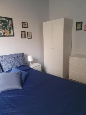 a bedroom with a blue bed and a white cabinet at House Cocò in Rome