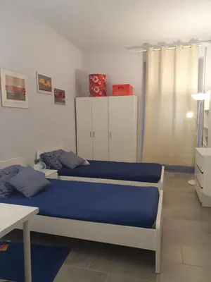 a bedroom with two beds with blue sheets at House Cocò in Rome