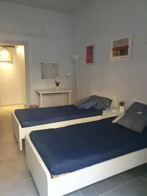 a bedroom with a large bed with blue sheets at House Cocò in Rome