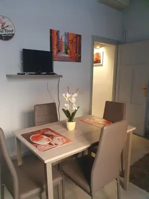 a dining room table with chairs and a laptop on the wall at House Cocò in Rome