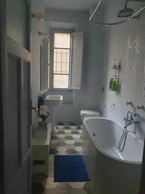 a bathroom with a tub and a toilet and a sink at House Cocò in Rome