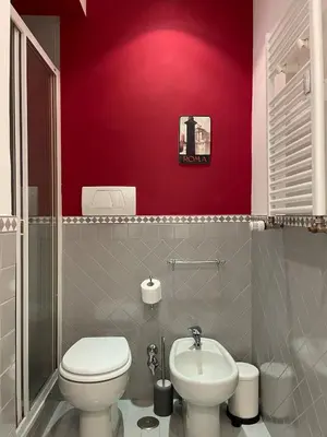 a bathroom with a white toilet and a sink at Lilla’s Apartment in Rome