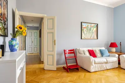 a living room with a white couch and a red chair at Lilla’s Apartment in Rome