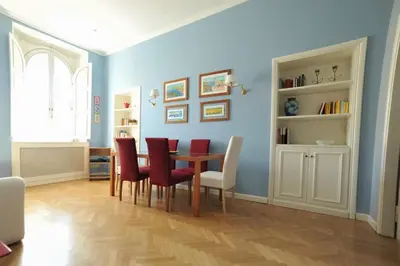 a dining room with a table and red chairs at Lilla’s Apartment in Rome