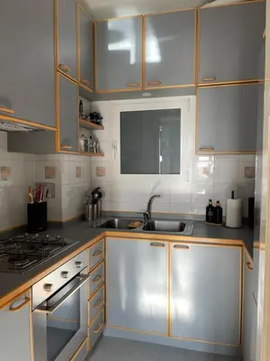 a kitchen with stainless steel appliances and wooden cabinets at Lilla’s Apartment in Rome