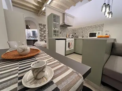 a kitchen and living room with a table with a cup on it at Beloved Trastevere in Rome