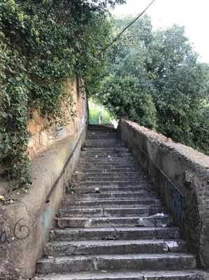 a set of stone stairs with trees and bushes at Beloved Trastevere in Rome