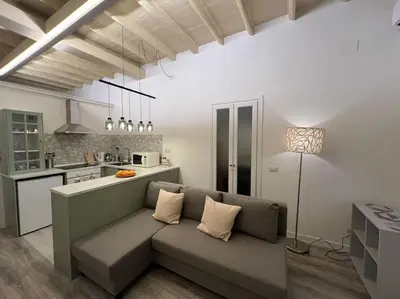a living room with a couch and a kitchen at Beloved Trastevere in Rome