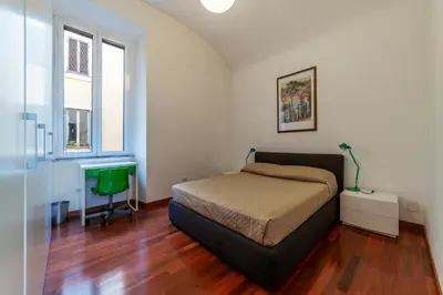 a bedroom with a bed and a desk and a window at GuestHost - San Giovanni in Laterano Dazzling Apartment in Rome