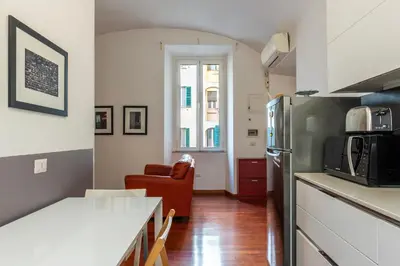a kitchen with a refrigerator and a living room at GuestHost - San Giovanni in Laterano Dazzling Apartment in Rome