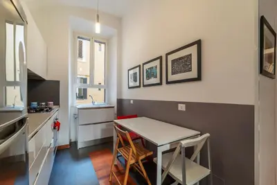a kitchen with a table and two stools at GuestHost - San Giovanni in Laterano Dazzling Apartment in Rome