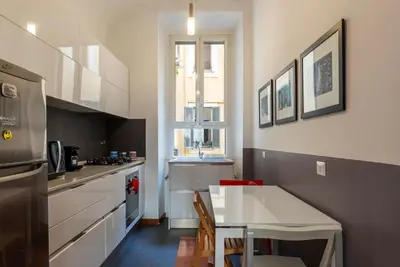 a kitchen with a table and a small kitchen with a counter at GuestHost - San Giovanni in Laterano Dazzling Apartment in Rome