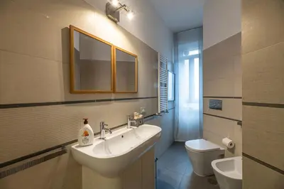 a bathroom with a sink and a toilet and a mirror at Domus Villa Scipioni in Rome