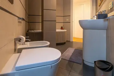a bathroom with a white toilet and a sink at Domus Villa Scipioni in Rome