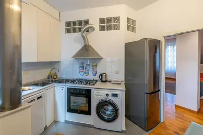 a kitchen with a stove and a washing machine at Domus Villa Scipioni in Rome