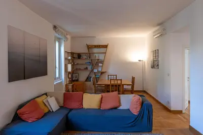a living room with a blue couch with colorful pillows at Domus Villa Scipioni in Rome