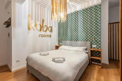 a bedroom with a king sized bed with a chandelier at Koba Rooms Nomentano in Rome