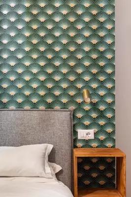 a bedroom with a bed and a green wallpaper at Koba Rooms Nomentano in Rome