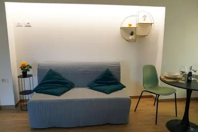 a couch with blue pillows in a room with a table at San Peter View in Rome