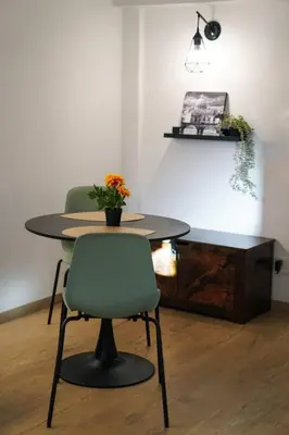 a table with two chairs and a vase of flowers on it at San Peter View in Rome