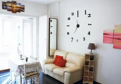 a living room with a couch and a clock on the wall at Appartamento 